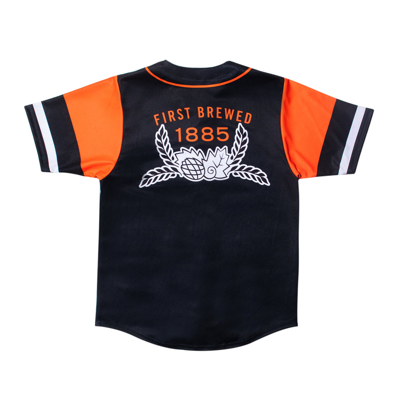 back of baseball jersey with "first brewed 1885" in orange font and leaves design below it