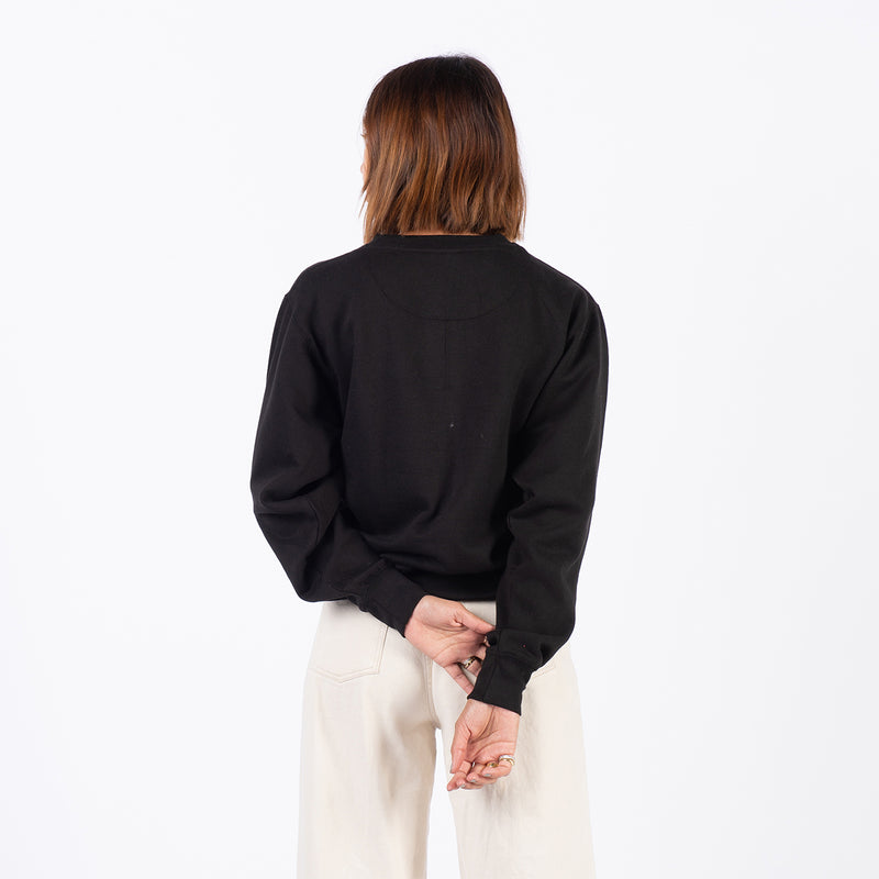 back of woman standing with plain black long sleeve on